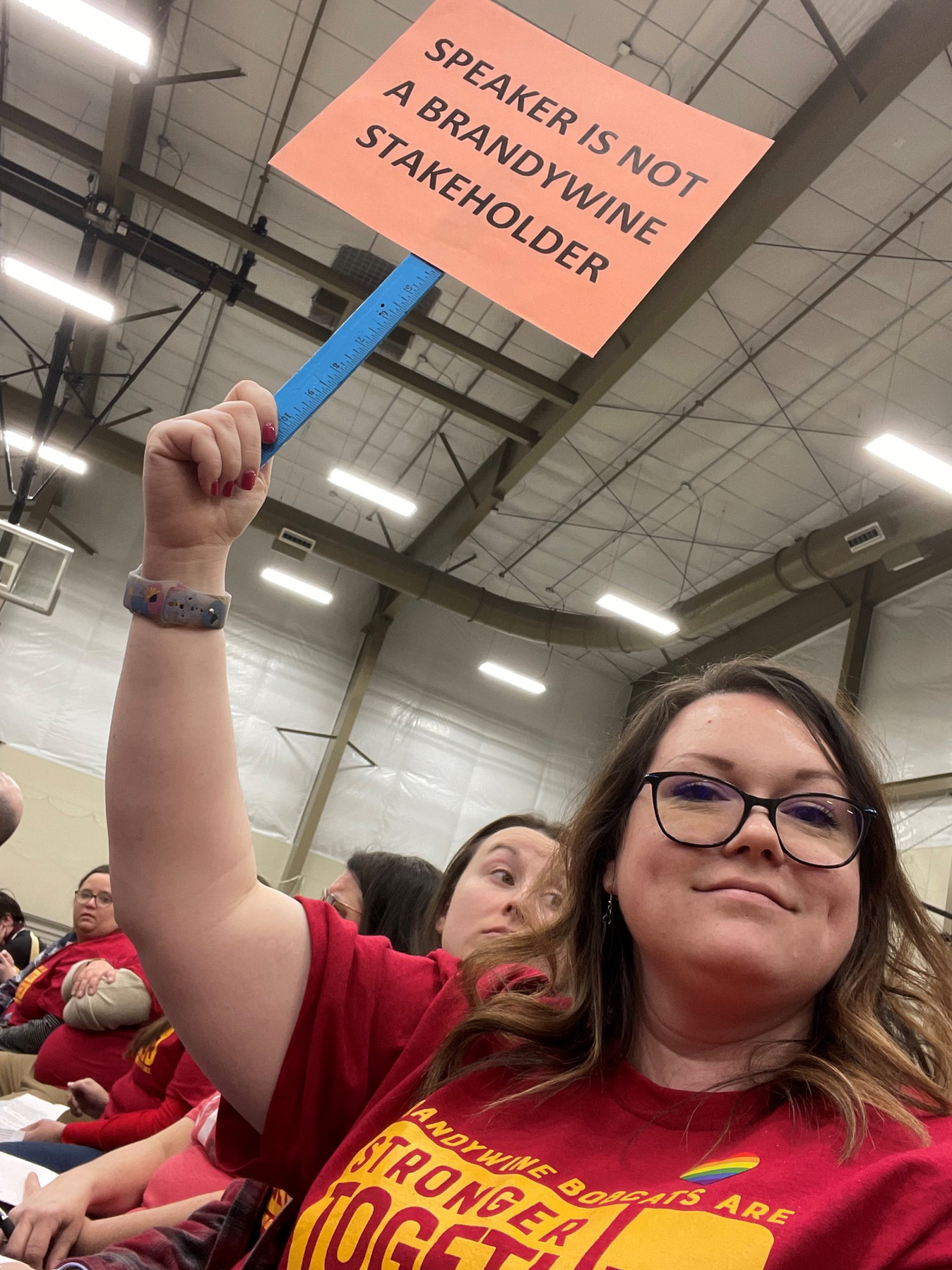 School secretary Amanda Cousineau uses a sign to indicate when people