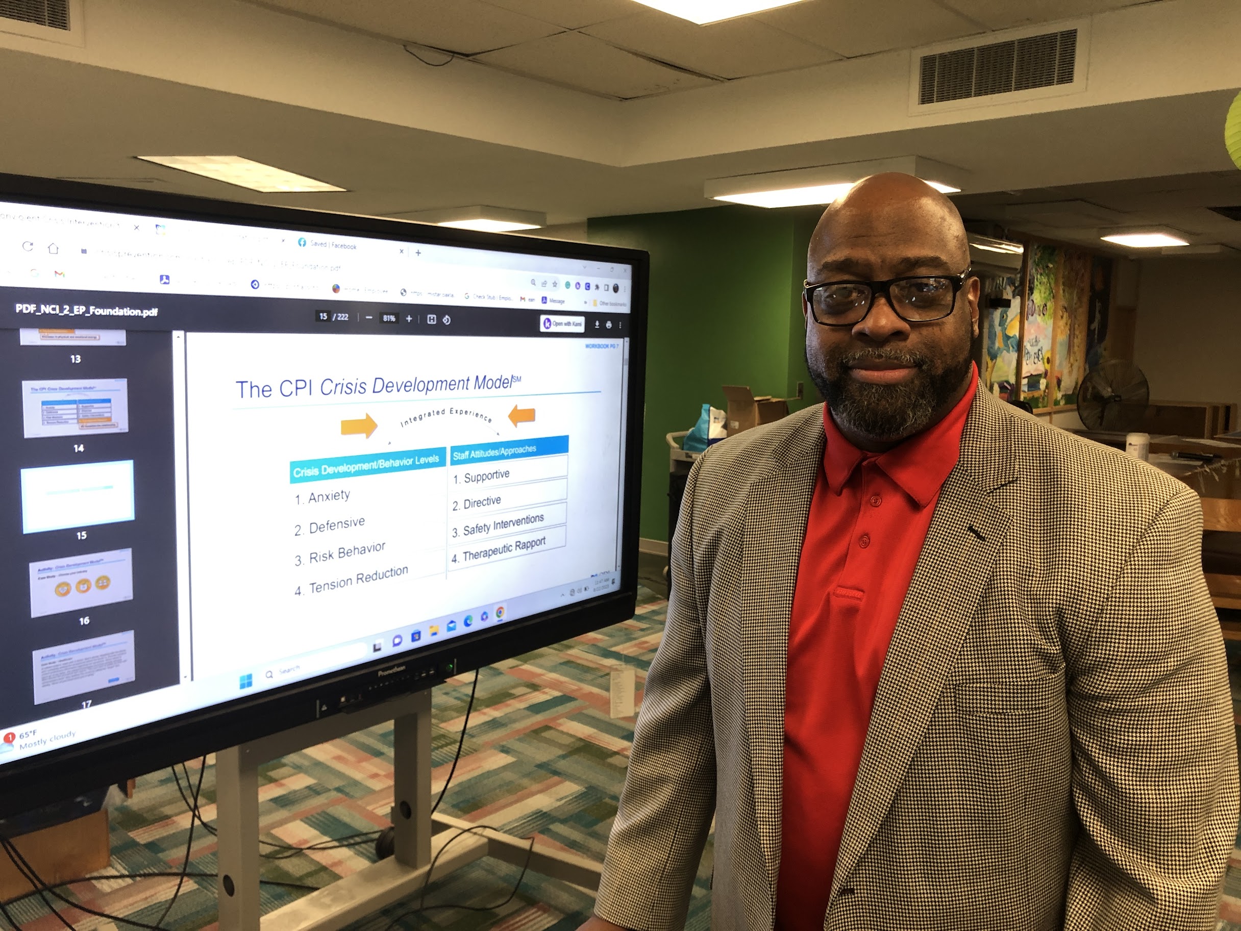 A photo of Fred McFadden posing in front of a data screen