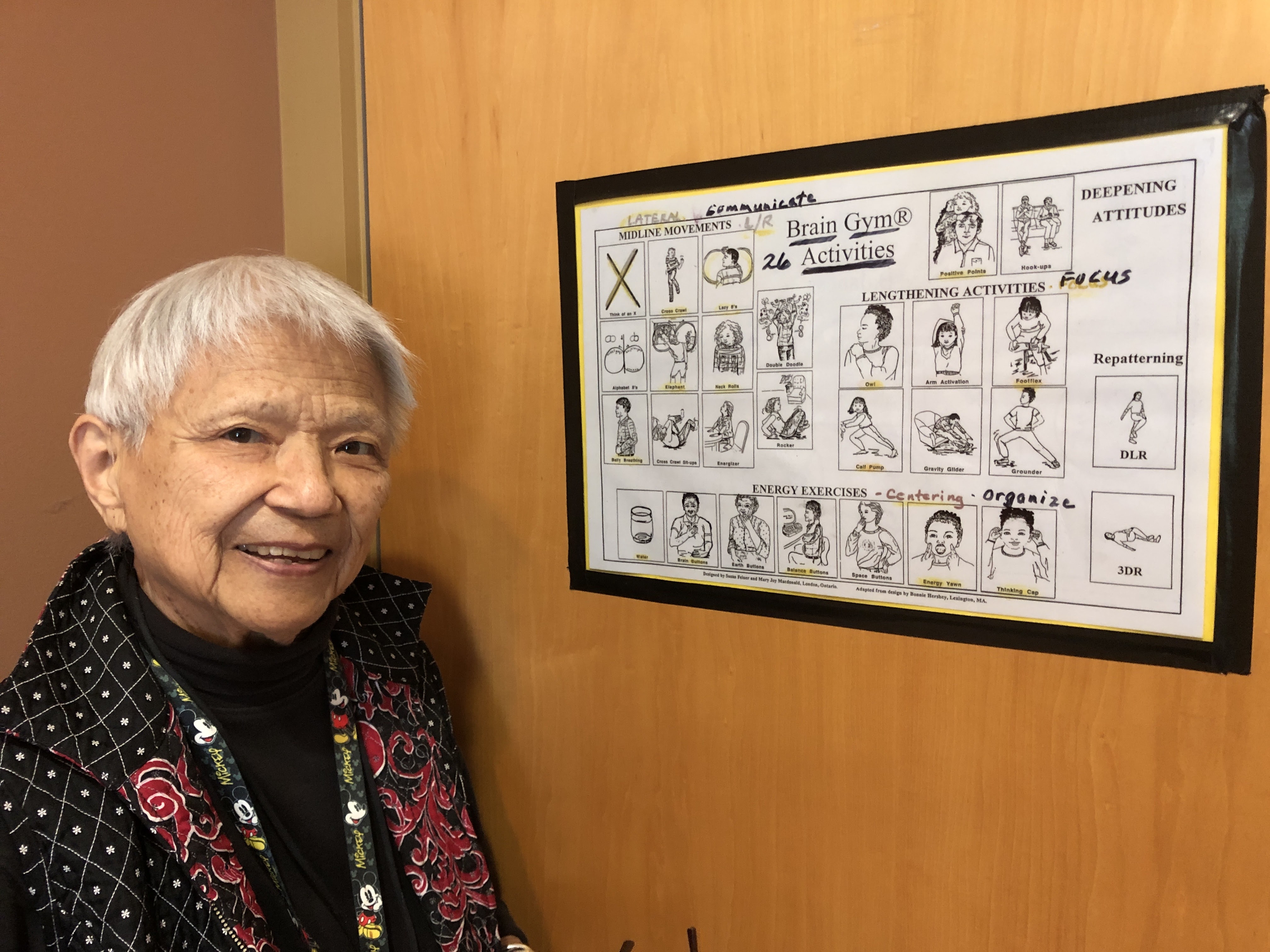 A photo of Opal Wong standing next to an instruction chart.