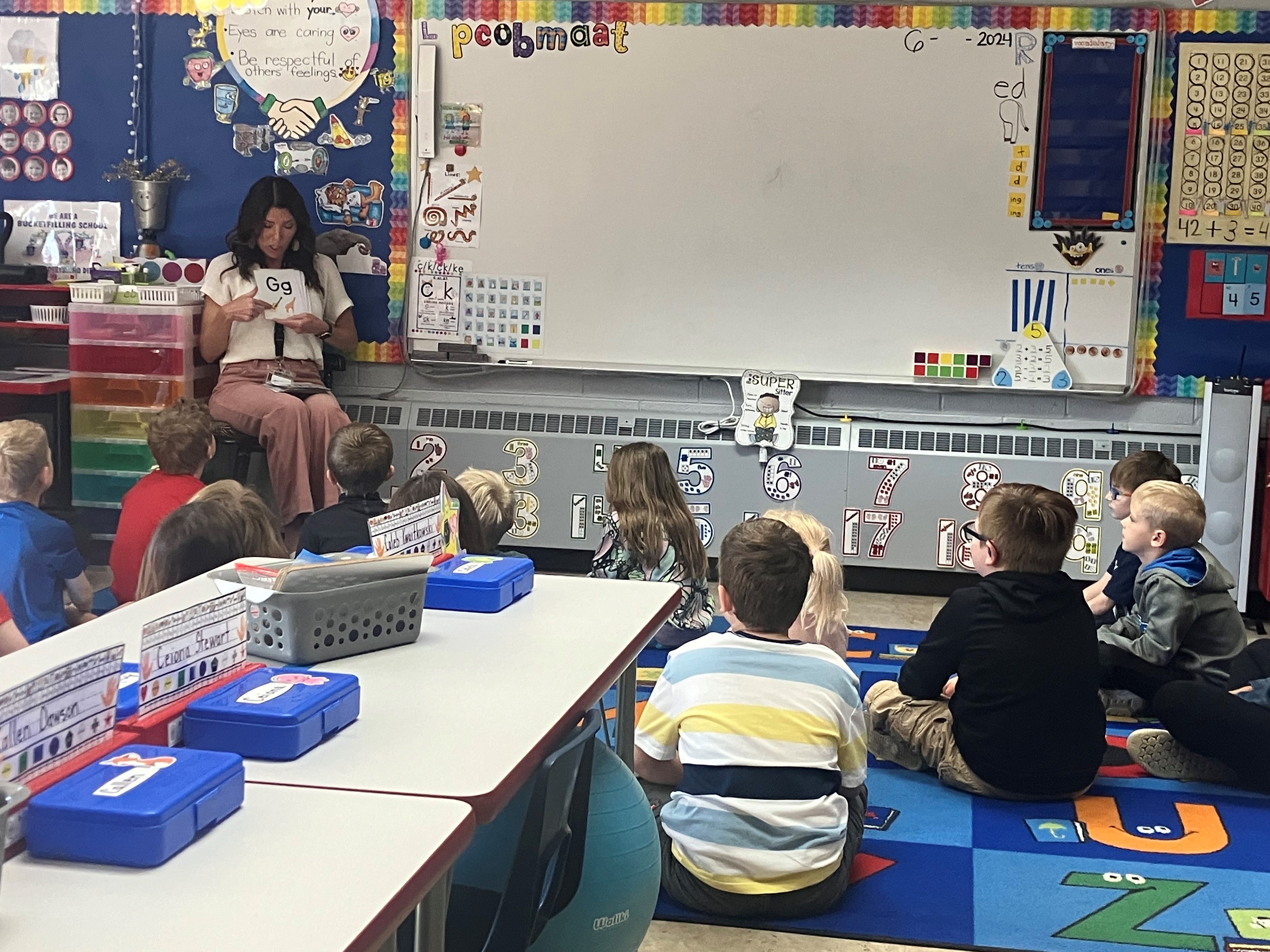 A photo of a teacher and students in a classroom