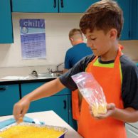 A photo of a student preparing a dish in a kitchen