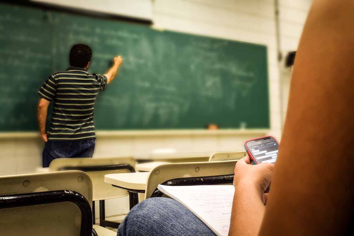 An image of a student texting during class 